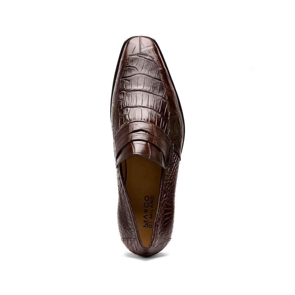 The Matteo Brown by Marco Di Milano is a pair of brown luxury loafers with a crocodile pattern; one shoe lies flat while the other is propped to showcase the sole and elegant hand-painted finishes.