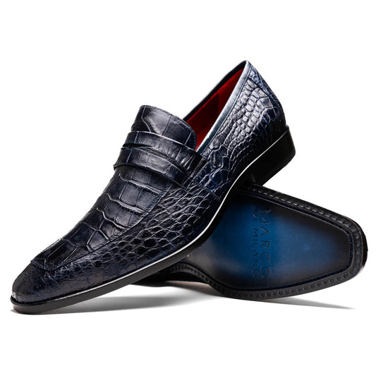 A pair of Matteo Navy loafers by Marco Di Milano, crafted in crocodile-pattern navy leather with a penny strap, red interior lining, and black soles; one shoe props against the other to reveal the sole.