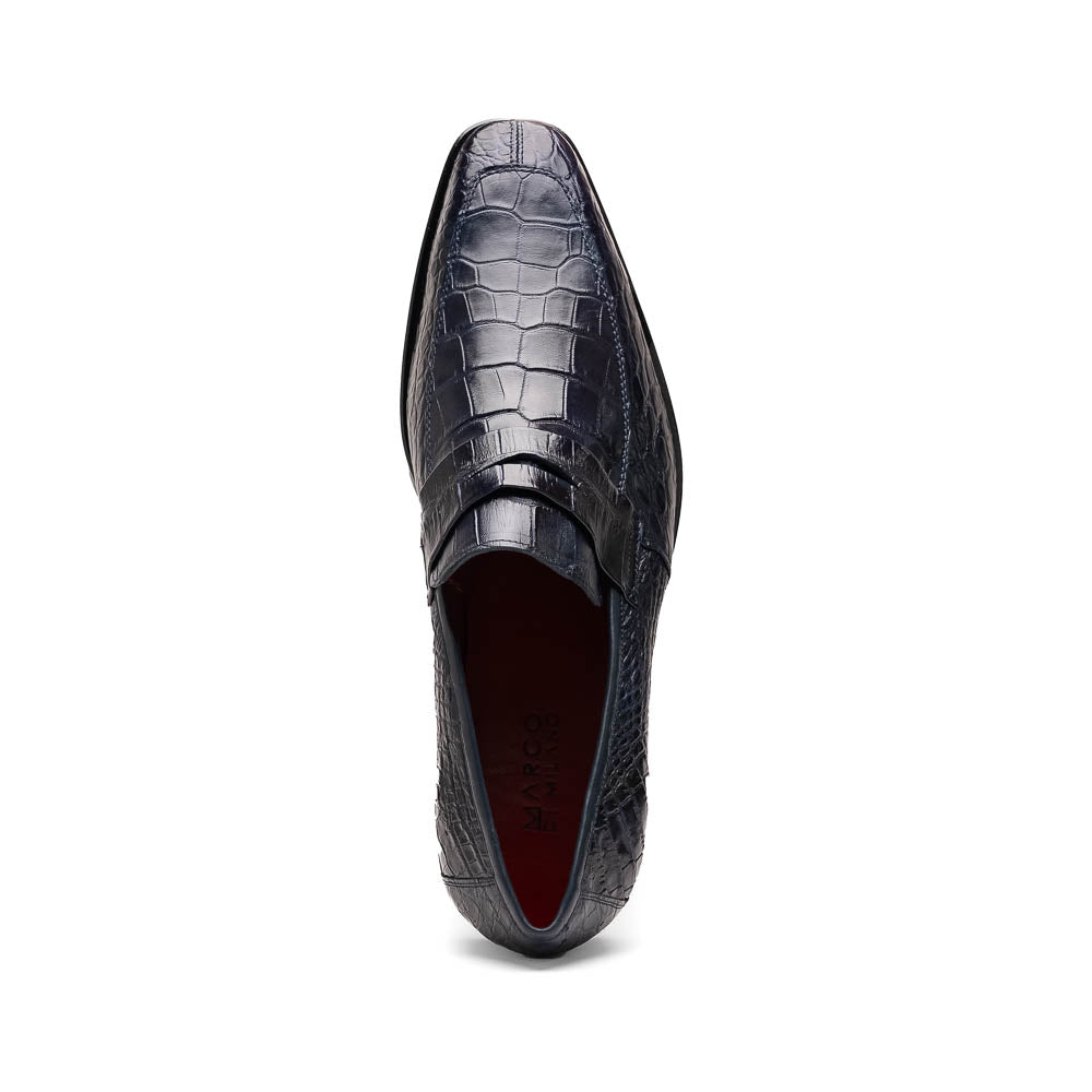 A pair of Matteo Navy loafers by Marco Di Milano, crafted in crocodile-pattern navy leather with a penny strap, red interior lining, and black soles; one shoe props against the other to reveal the sole.