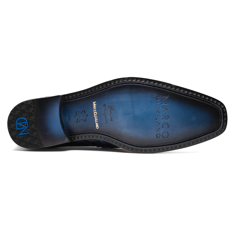 A pair of Matteo Navy loafers by Marco Di Milano, crafted in crocodile-pattern navy leather with a penny strap, red interior lining, and black soles; one shoe props against the other to reveal the sole.