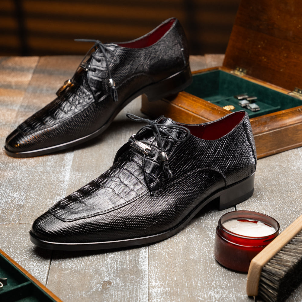 A pair of Merida Black dress derby shoes by Marco Di Milano, crafted from textured black leather caiman—one upright and one on its side revealing the brown sole stamped with the brand’s logo—an unmistakable statement in luxury footwear.