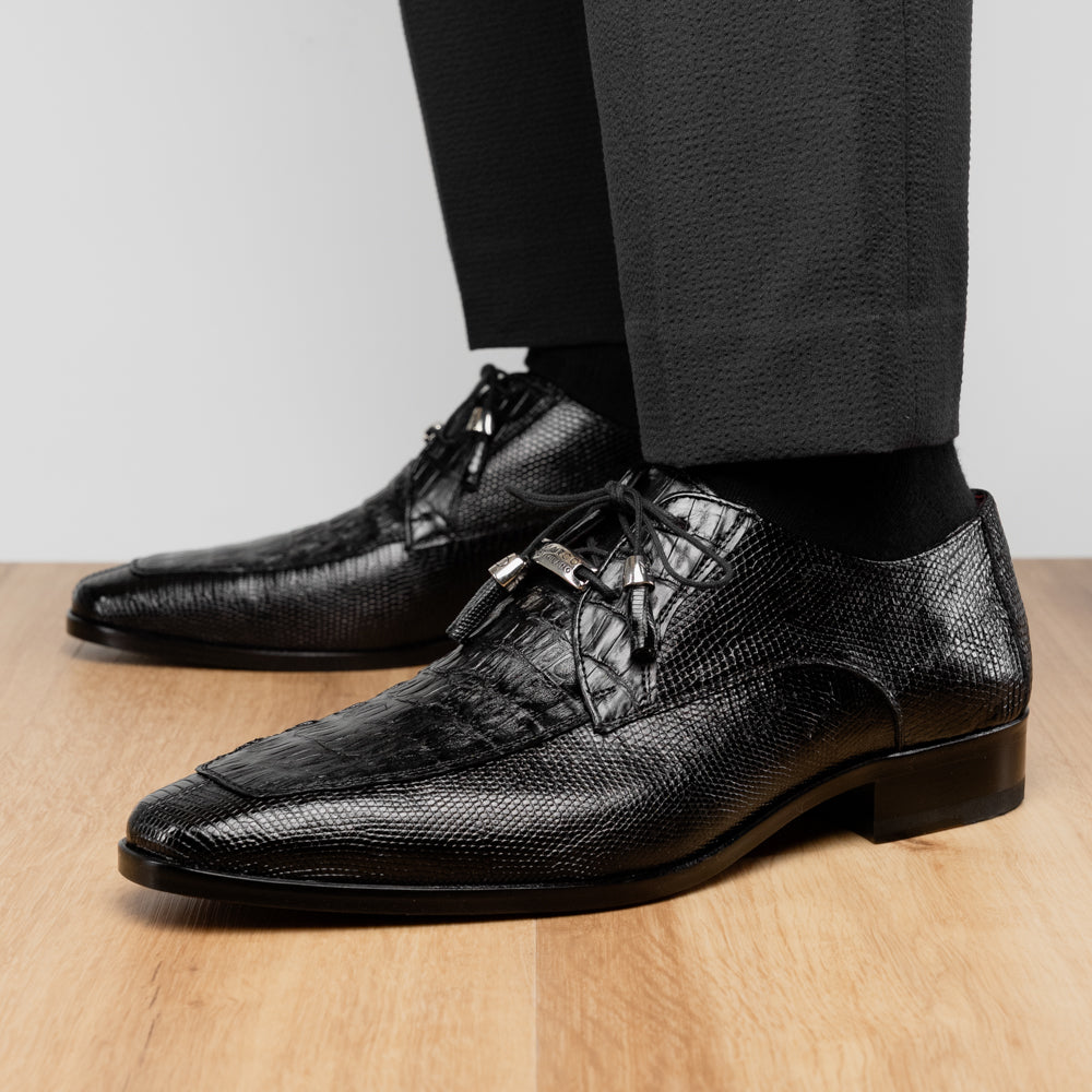 A pair of Merida Black dress derby shoes by Marco Di Milano, crafted from textured black leather caiman—one upright and one on its side revealing the brown sole stamped with the brand’s logo—an unmistakable statement in luxury footwear.