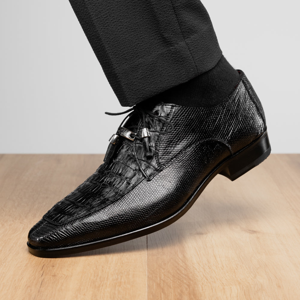 A pair of Merida Black dress derby shoes by Marco Di Milano, crafted from textured black leather caiman—one upright and one on its side revealing the brown sole stamped with the brand’s logo—an unmistakable statement in luxury footwear.
