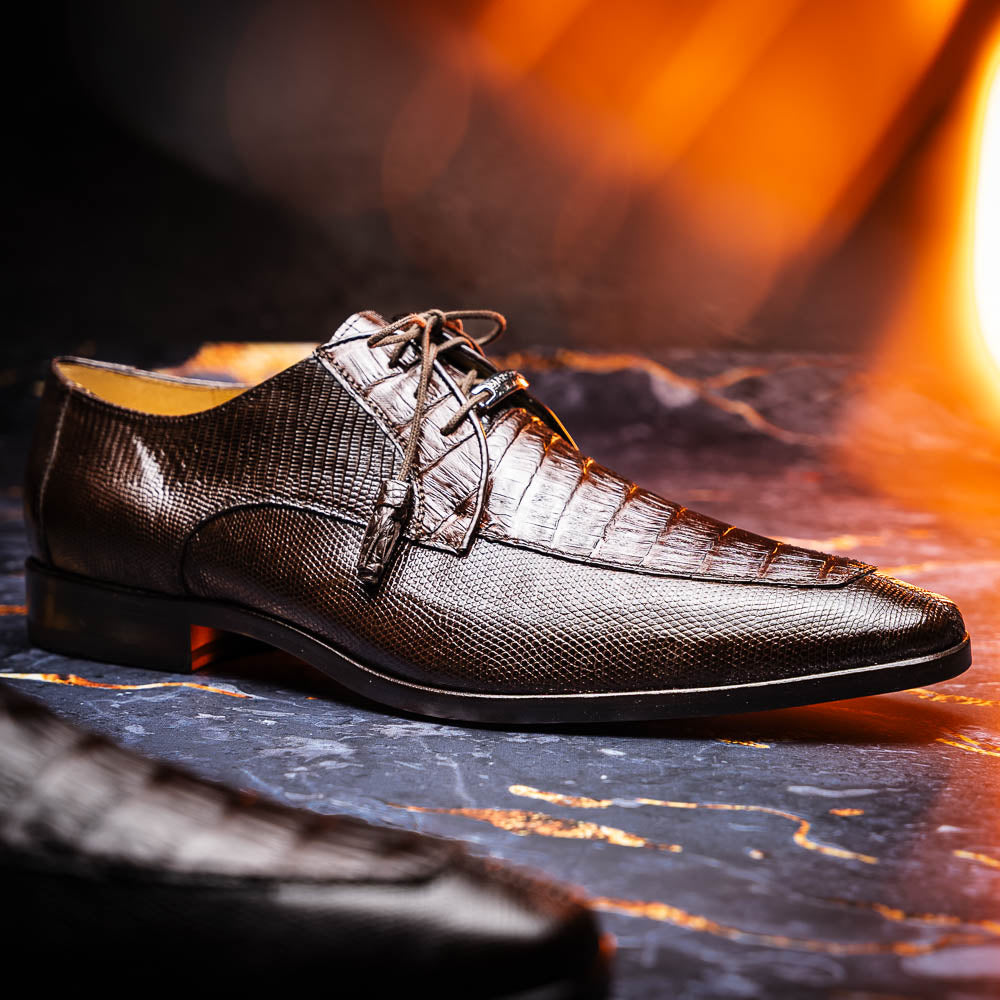 The Merida Brown by Marco Di Milano: a pair of dark brown, textured caiman dress derby shoes with laces—one upright and the other on its side revealing the sole—ideal for those seeking genuine exotic luxury footwear.