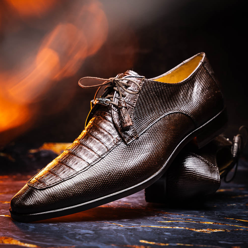 The Merida Brown by Marco Di Milano: a pair of dark brown, textured caiman dress derby shoes with laces—one upright and the other on its side revealing the sole—ideal for those seeking genuine exotic luxury footwear.
