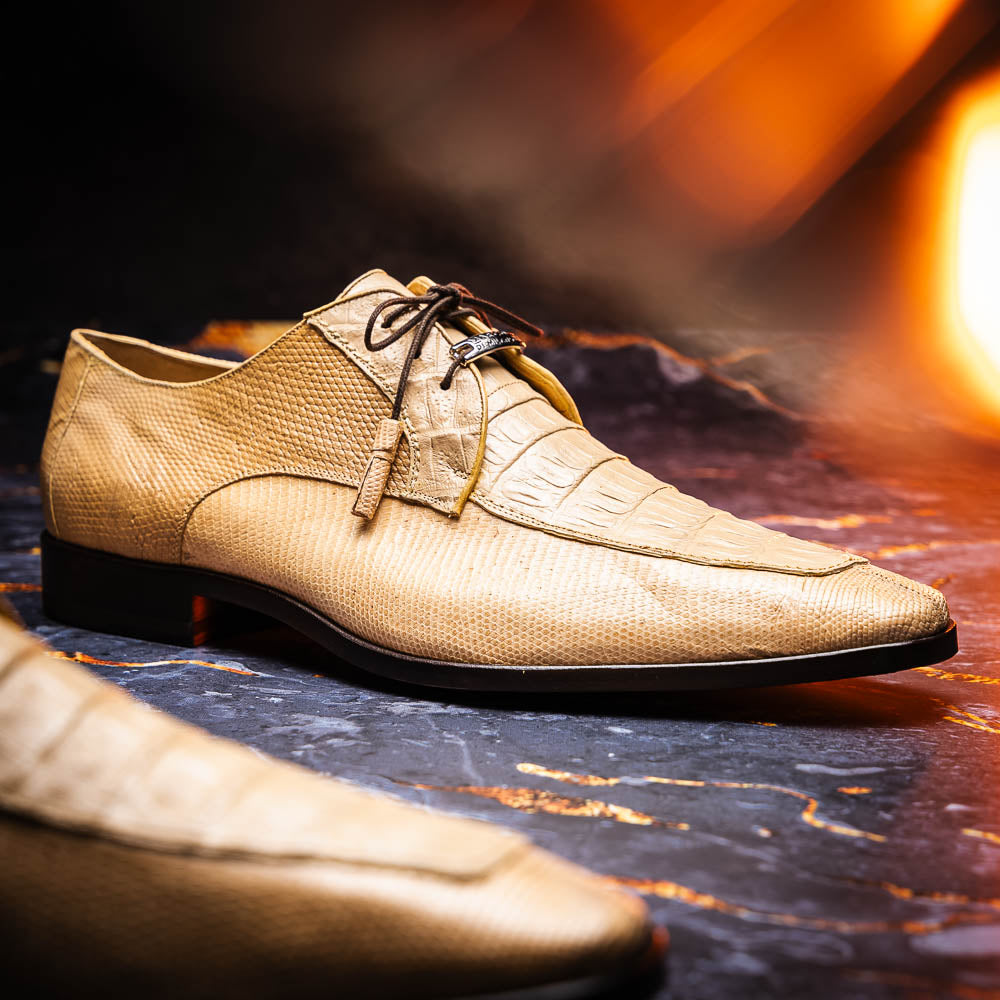 A pair of beige Merida Orix dress derby shoes by Marco Di Milano with black laces, one upright and one leaning to reveal the branded sole—a striking statement in luxury footwear.