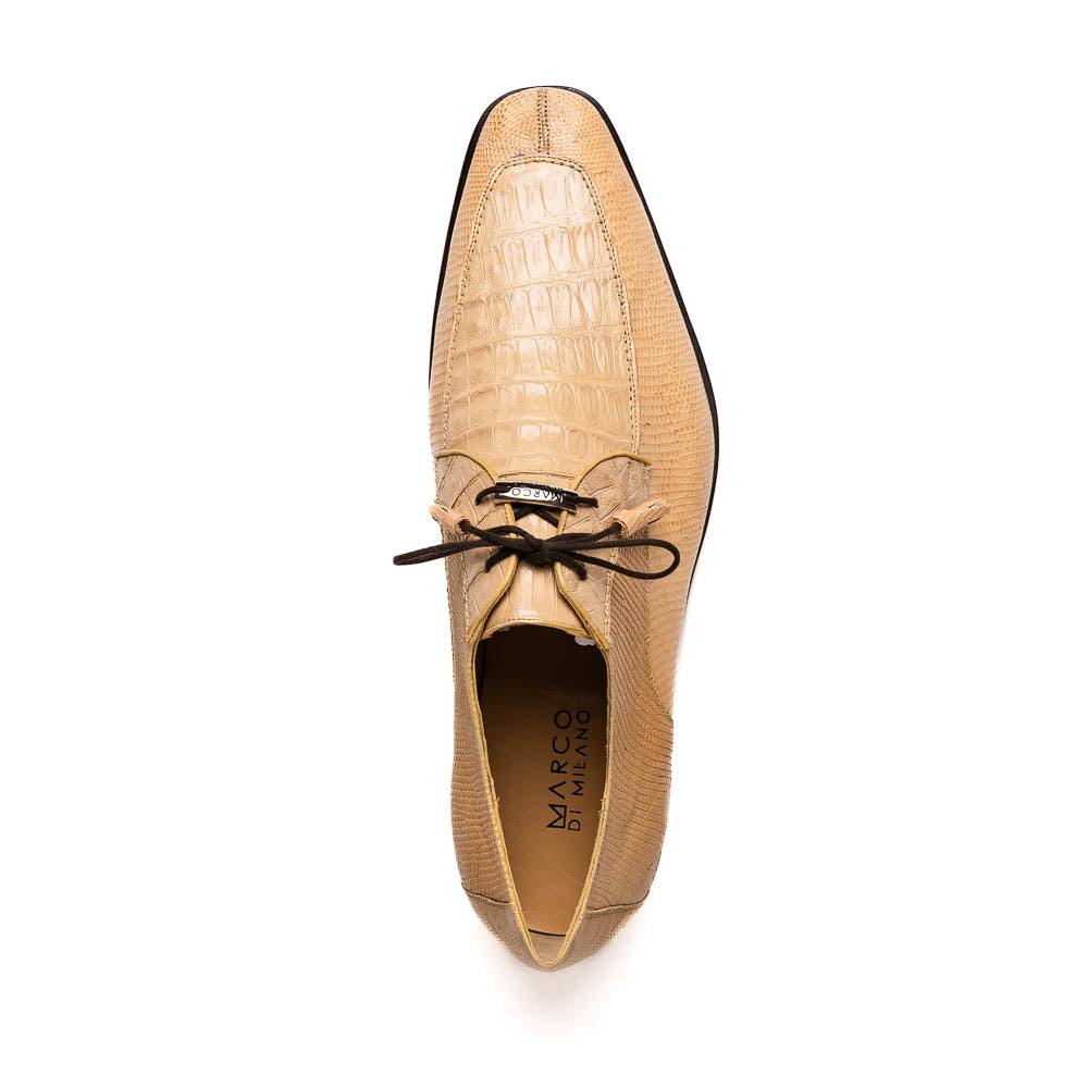 A pair of beige Merida Orix dress derby shoes by Marco Di Milano with black laces, one upright and one leaning to reveal the branded sole—a striking statement in luxury footwear.