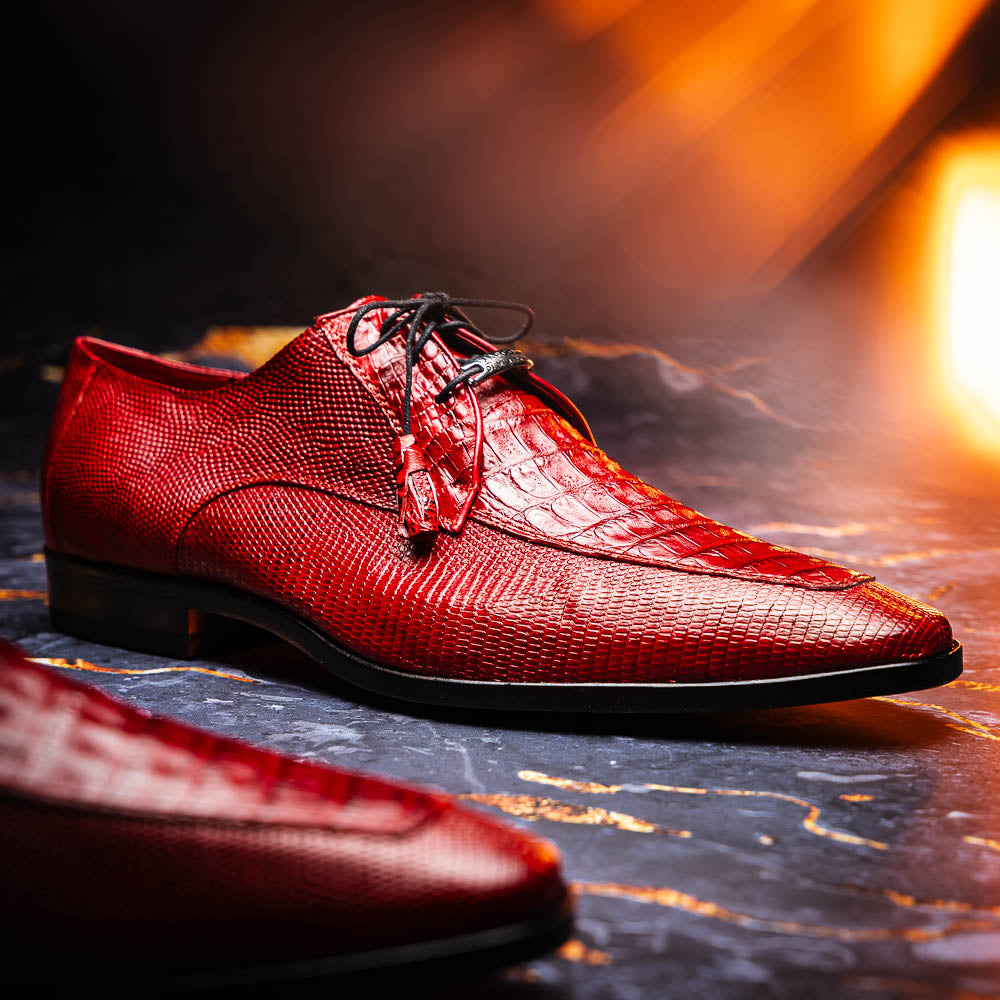 The Merida Red by Marco Di Milano are red textured leather luxury dress shoes with black laces and red tassels, shown both upright and sideways to highlight their hand-painted sole finishes.