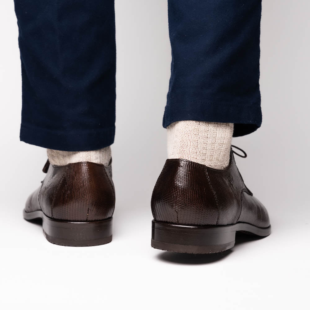 The Merida Brown by Marco Di Milano: a pair of dark brown, textured caiman dress derby shoes with laces—one upright and the other on its side revealing the sole—ideal for those seeking genuine exotic luxury footwear.