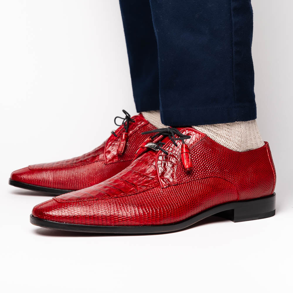 The Merida Red by Marco Di Milano are red textured leather luxury dress shoes with black laces and red tassels, shown both upright and sideways to highlight their hand-painted sole finishes.