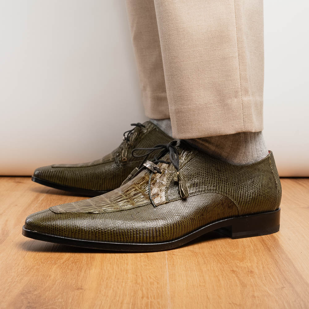 The Merida Olive Green by Marco Di Milano is a pair of olive green textured leather caiman Derby shoes with black laces, red interior lining, dark soles, embossed branding, and hand-painted finishes—a true luxury statement.