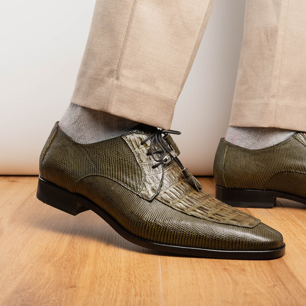 The Merida Olive Green by Marco Di Milano is a pair of olive green textured leather caiman Derby shoes with black laces, red interior lining, dark soles, embossed branding, and hand-painted finishes—a true luxury statement.