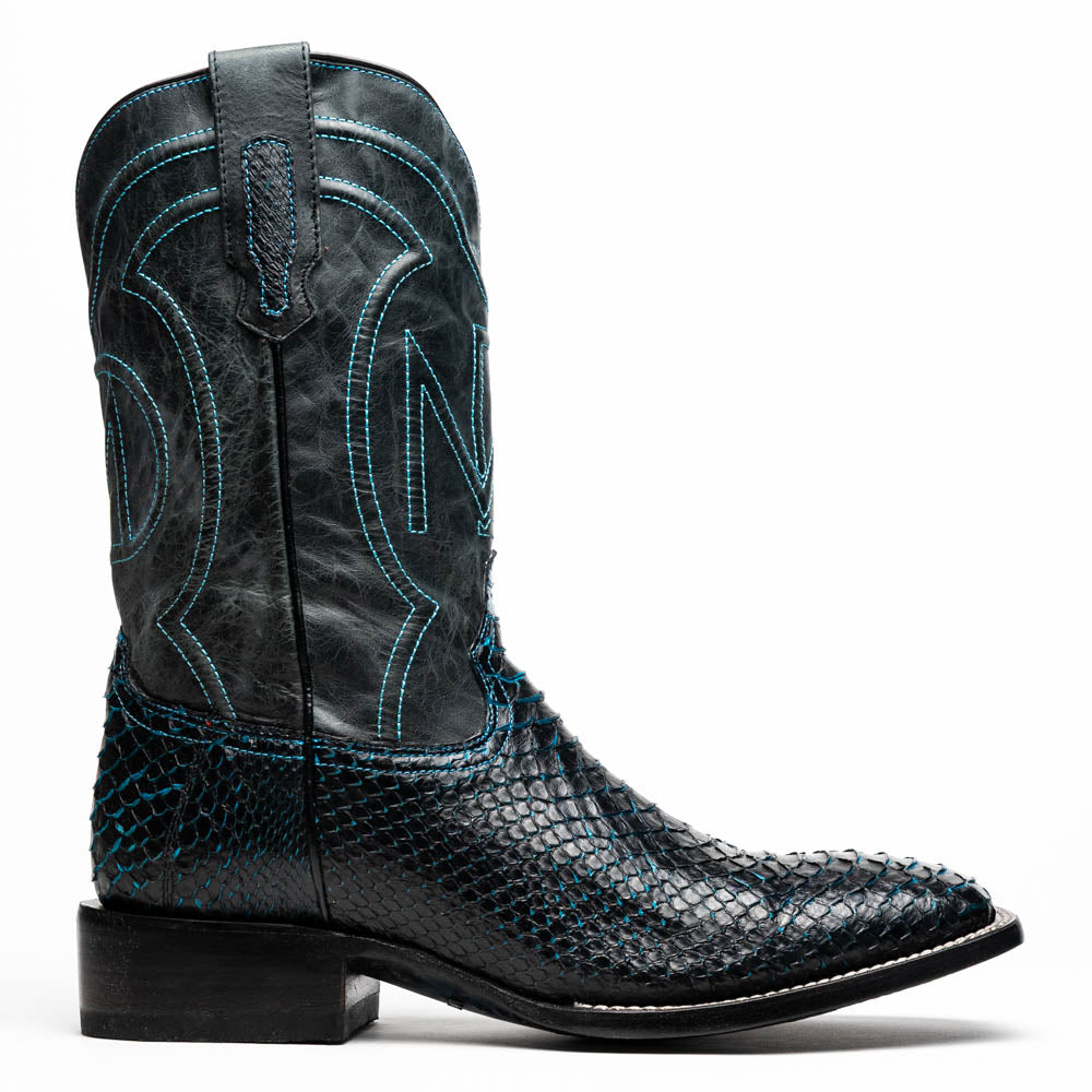 The Missouri Black / Blue boots by Marco Di Milano are handcrafted men's cowboy boots in black and blue, featuring genuine python skin and a textured snakeskin pattern—one boot upright, the other revealing the branded sole.