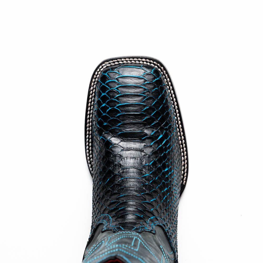 The Missouri Black / Blue boots by Marco Di Milano are handcrafted men's cowboy boots in black and blue, featuring genuine python skin and a textured snakeskin pattern—one boot upright, the other revealing the branded sole.