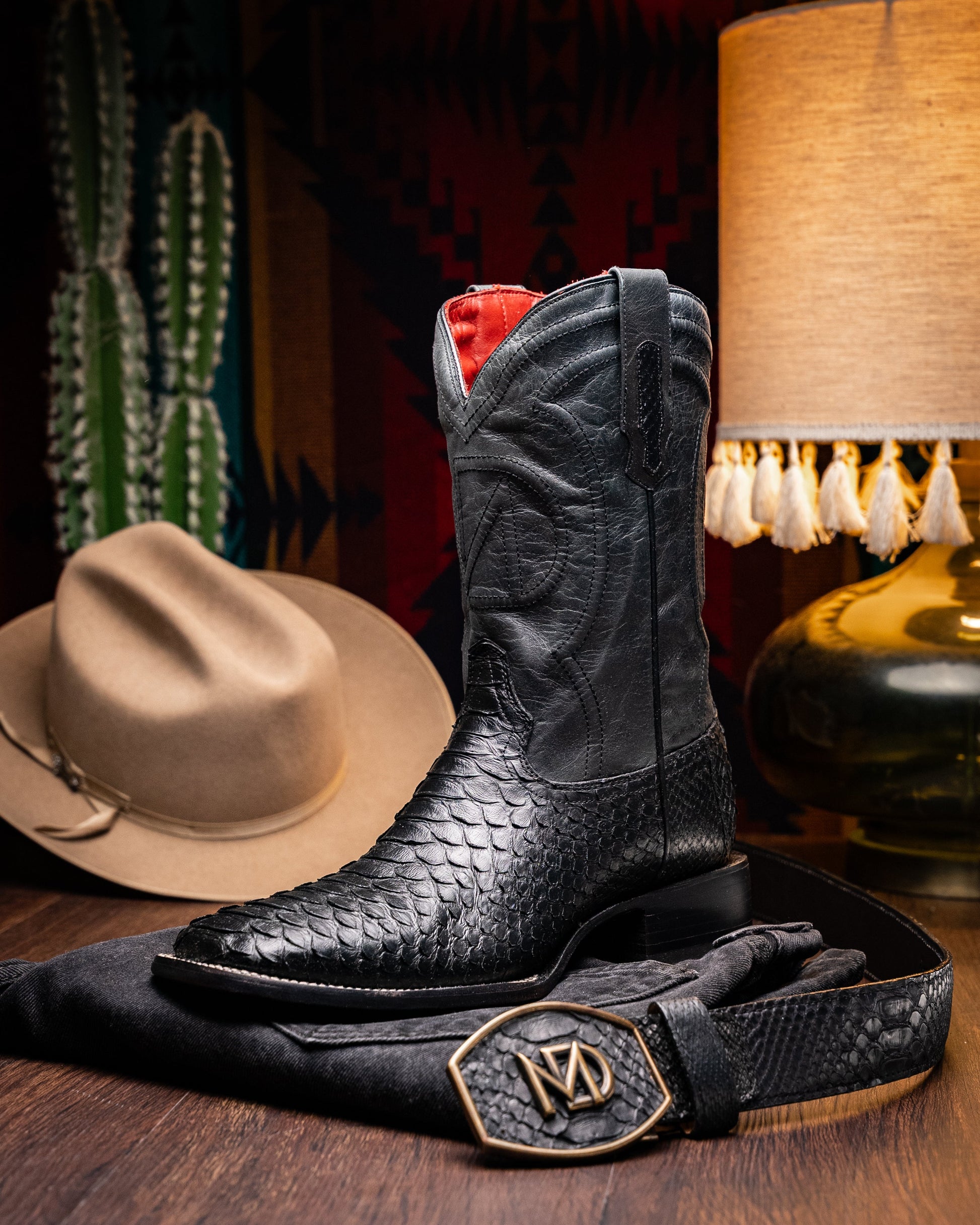 Missouri Black by Marco Di Milano: black, textured handcrafted men's boots with a red interior lining. One boot stands upright, the other shows the "MARCO DI MILANO" sole—exotic western boots for a bold statement.