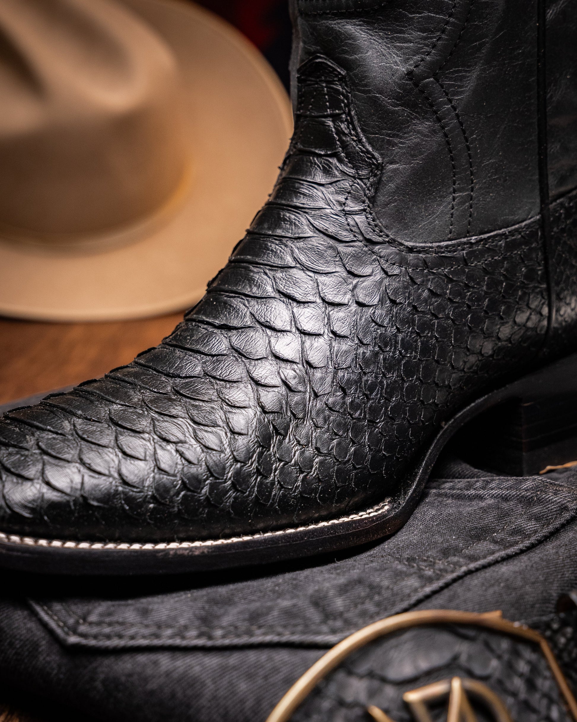 Missouri Black by Marco Di Milano: black, textured handcrafted men's boots with a red interior lining. One boot stands upright, the other shows the "MARCO DI MILANO" sole—exotic western boots for a bold statement.
