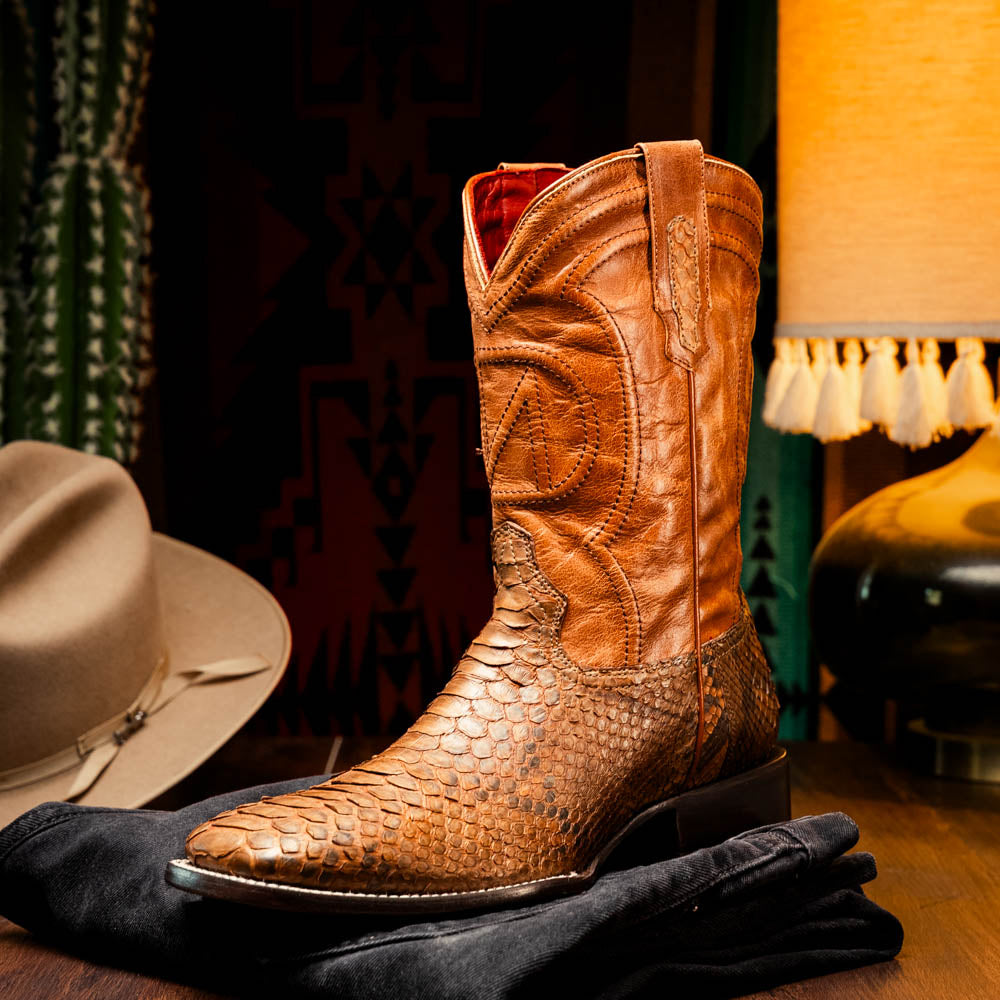 The Missouri Cognac boots by Marco Di Milano showcase classic style and premium detail with brown handcrafted leather, a textured snakeskin pattern, and distinctive branding on the sole.