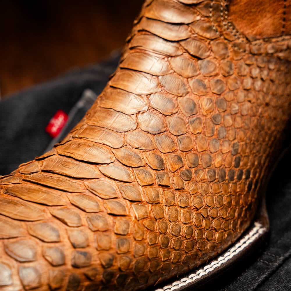 The Missouri Cognac boots by Marco Di Milano showcase classic style and premium detail with brown handcrafted leather, a textured snakeskin pattern, and distinctive branding on the sole.