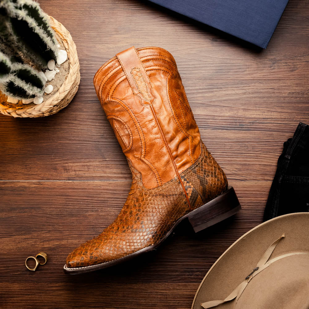 The Missouri Cognac boots by Marco Di Milano showcase classic style and premium detail with brown handcrafted leather, a textured snakeskin pattern, and distinctive branding on the sole.
