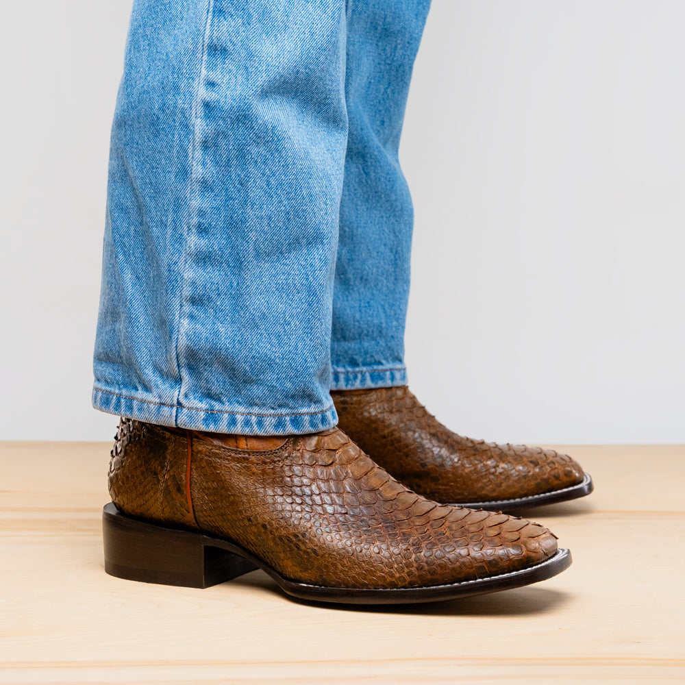 The Missouri Cognac boots by Marco Di Milano showcase classic style and premium detail with brown handcrafted leather, a textured snakeskin pattern, and distinctive branding on the sole.
