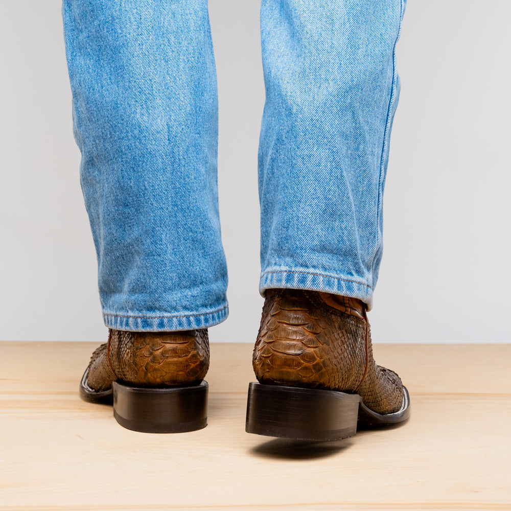 The Missouri Cognac boots by Marco Di Milano showcase classic style and premium detail with brown handcrafted leather, a textured snakeskin pattern, and distinctive branding on the sole.