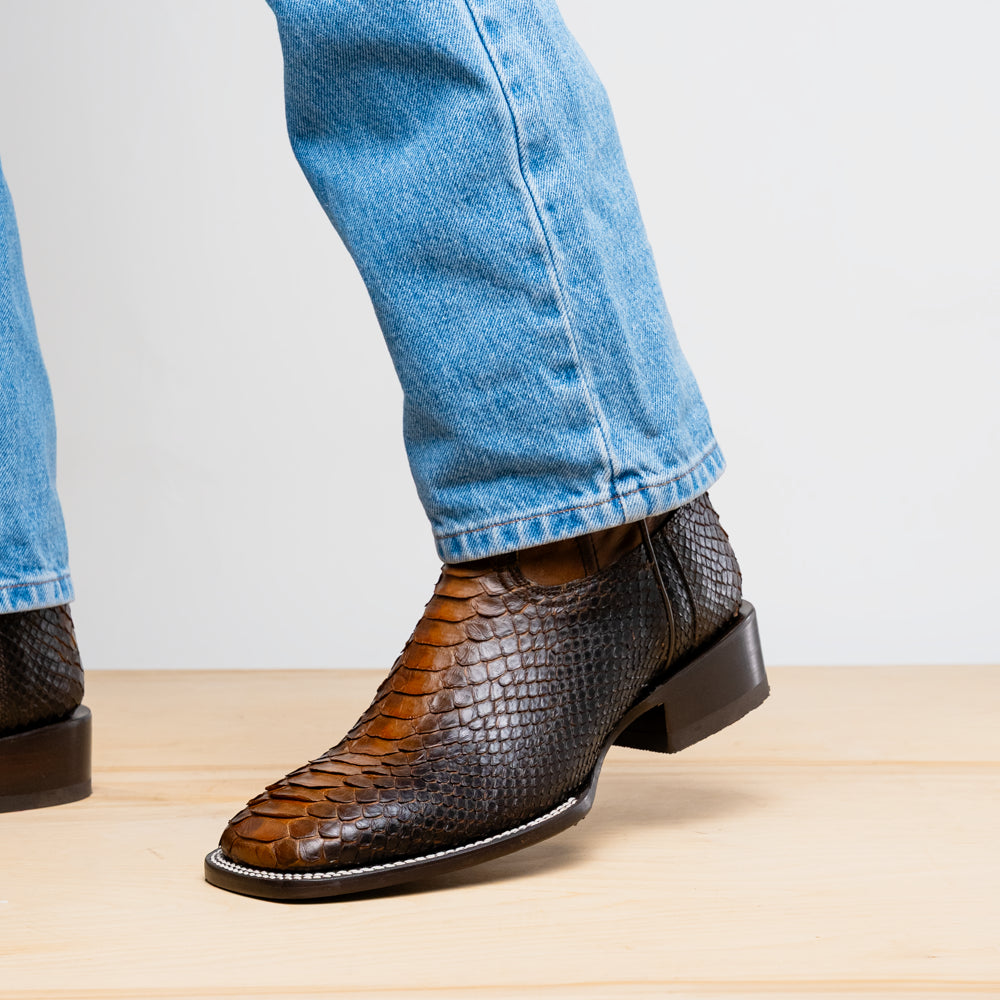 The Missouri Lisboa by Marco Di Milano offers men's cowboy boots with a textured snakeskin-style lower section, smooth upper, and a branded sole for a unique, handcrafted look.