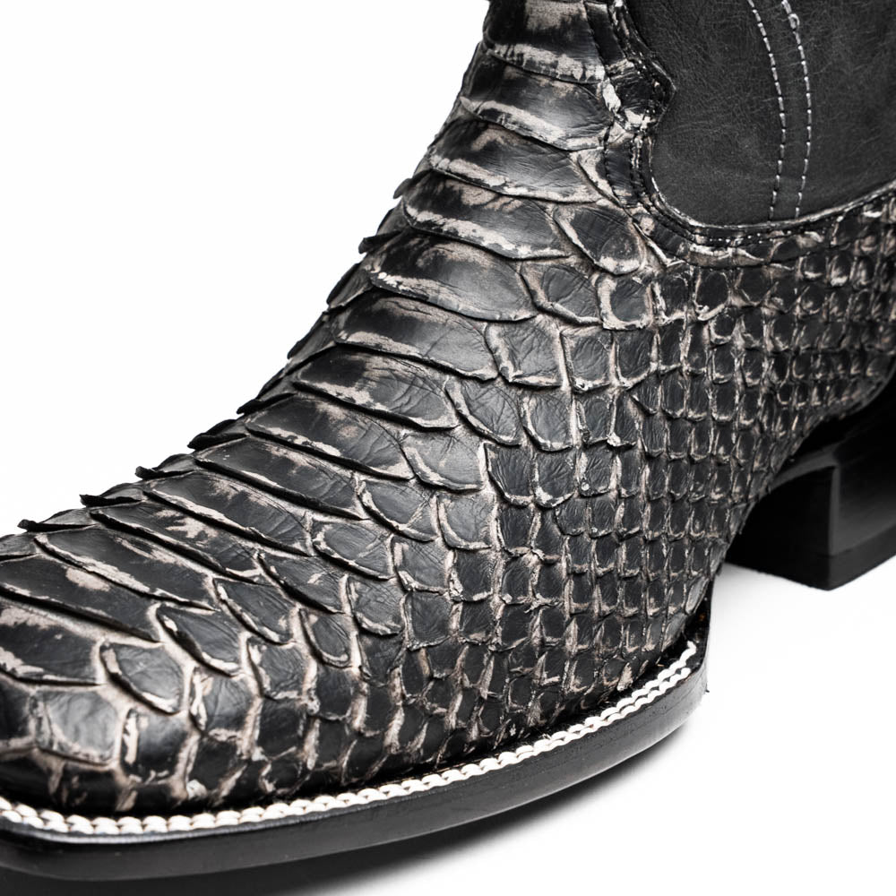 A pair of Missouri Stone White cowboy boots by Marco Di Milano, handcrafted in black textured python leather with branded soles, displayed on a white background.