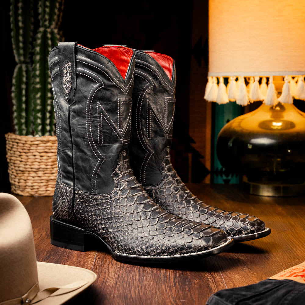 A pair of Missouri Stone White cowboy boots by Marco Di Milano, handcrafted in black textured python leather with branded soles, displayed on a white background.