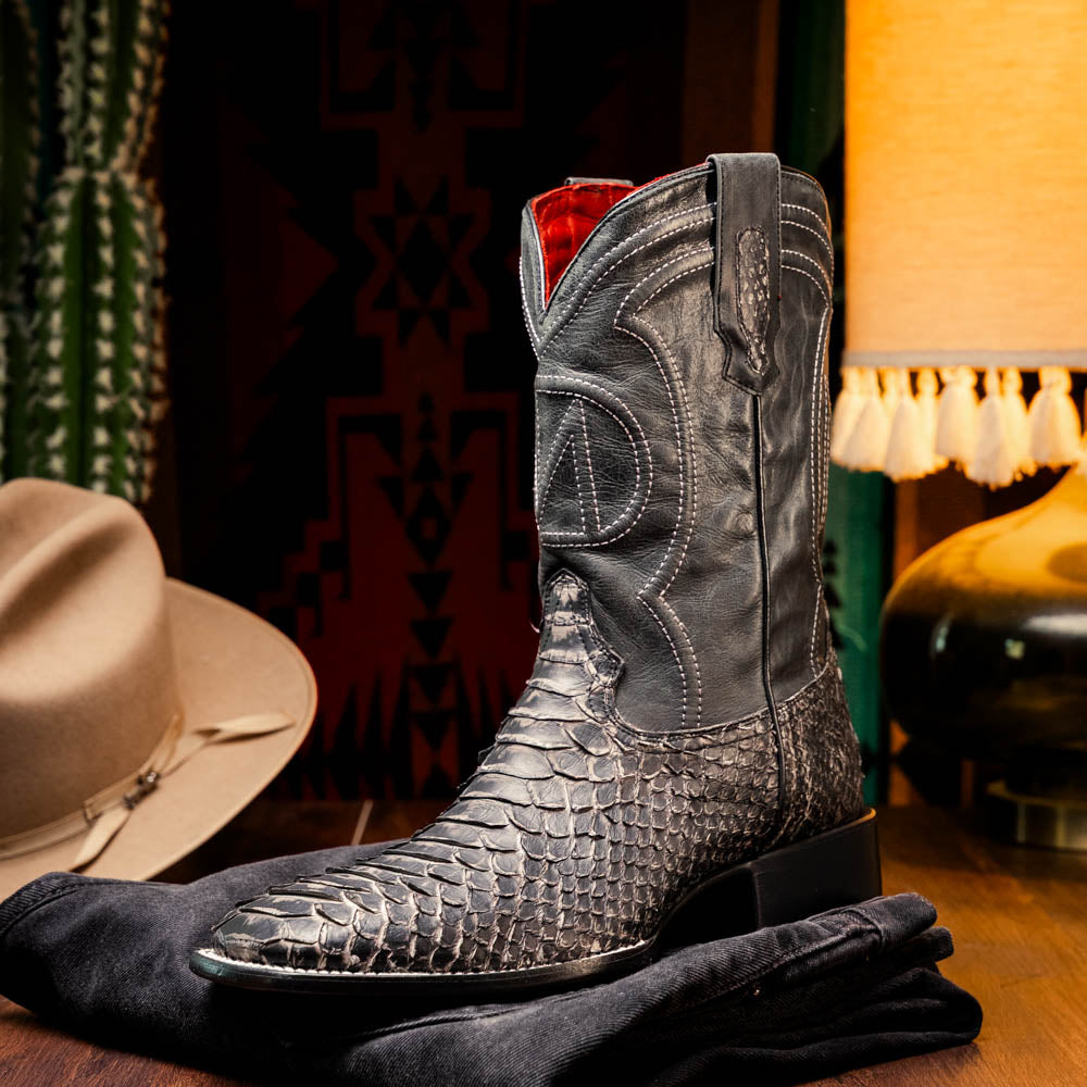 A pair of Missouri Stone White cowboy boots by Marco Di Milano, handcrafted in black textured python leather with branded soles, displayed on a white background.