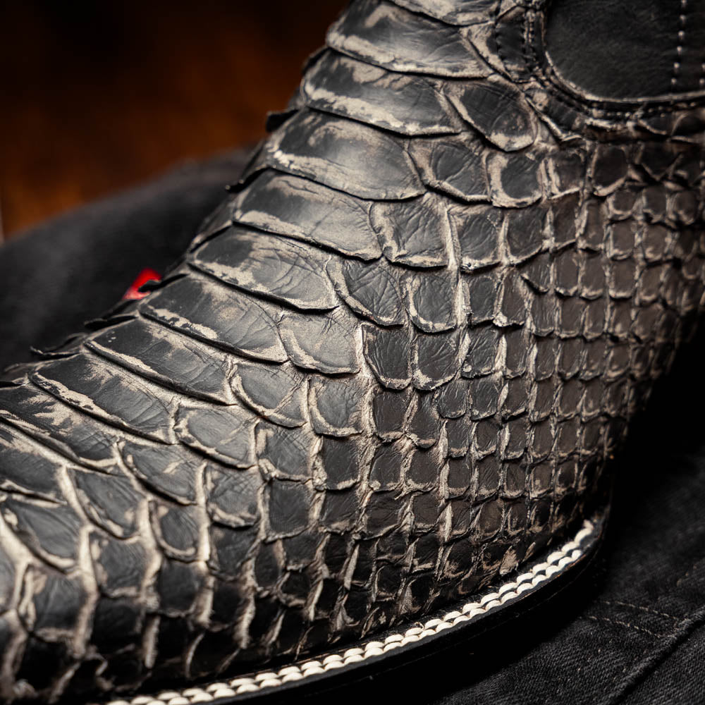 A pair of Missouri Stone White cowboy boots by Marco Di Milano, handcrafted in black textured python leather with branded soles, displayed on a white background.