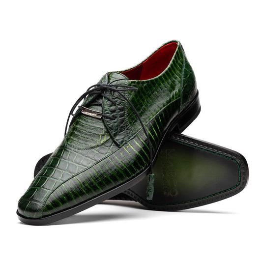 A pair of Moncalieri Green luxury shoes by Marco Di Milano, one upright with tied laces and the other on its side showing the sole—crocodile-patterned elegance at its finest.