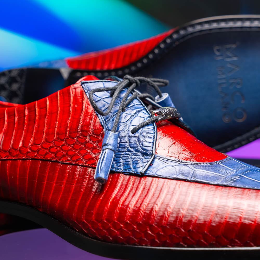 The Moncalieri Navy / Red by Marco Di Milano is a pair of men’s luxury shoes crafted from shiny red and blue crocodile leather with pointed toes, lace-up fronts, hand-painted finishes, and black soles.
