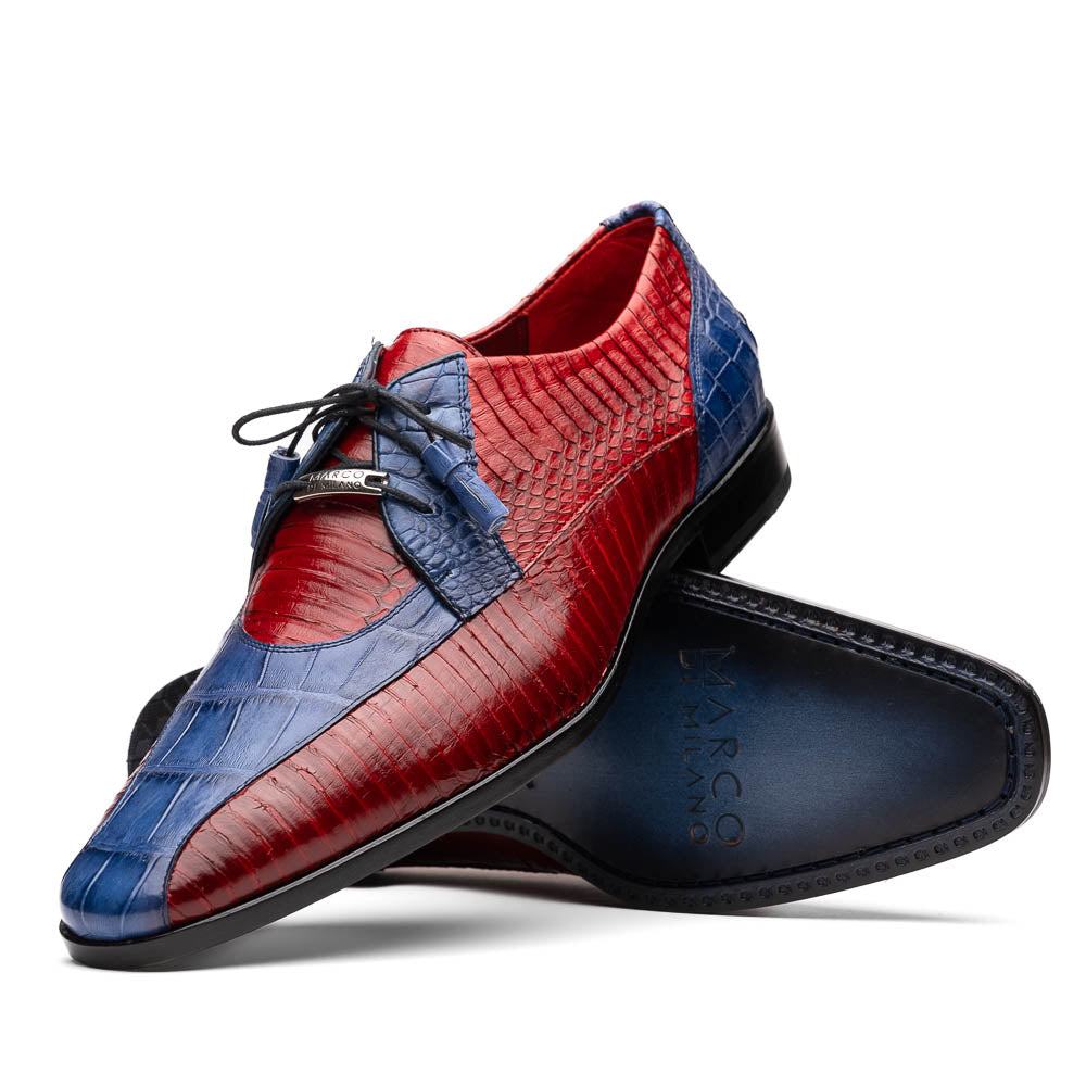 The Moncalieri Navy / Red by Marco Di Milano is a pair of men’s luxury shoes crafted from shiny red and blue crocodile leather with pointed toes, lace-up fronts, hand-painted finishes, and black soles.