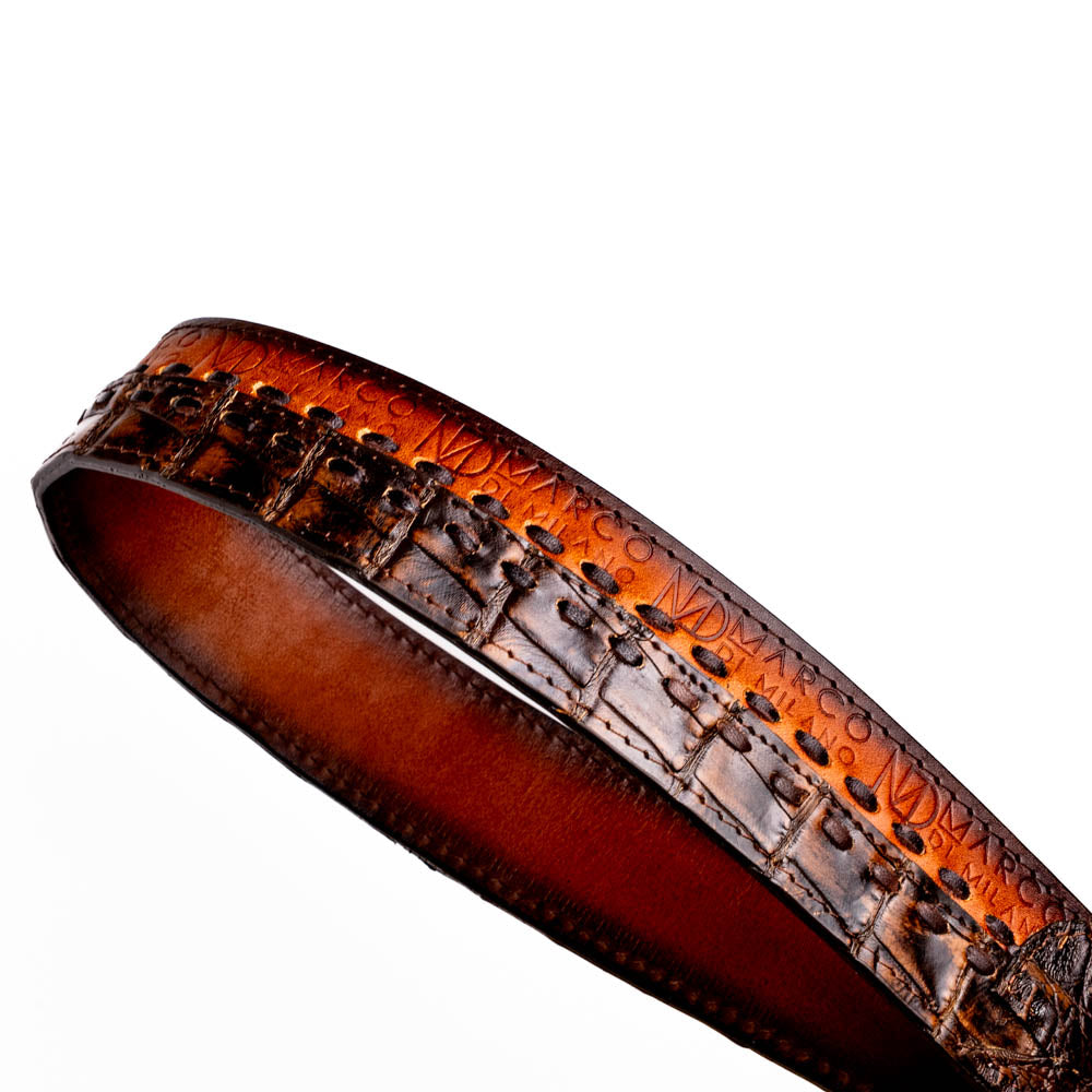 The Montana Belt Aged Brown by Marco Di Milano features aged brown leather with embossed patterns, metal studs, a bold gold MD monogram buckle, and the brand name on the strap for a sophisticated Western look.
