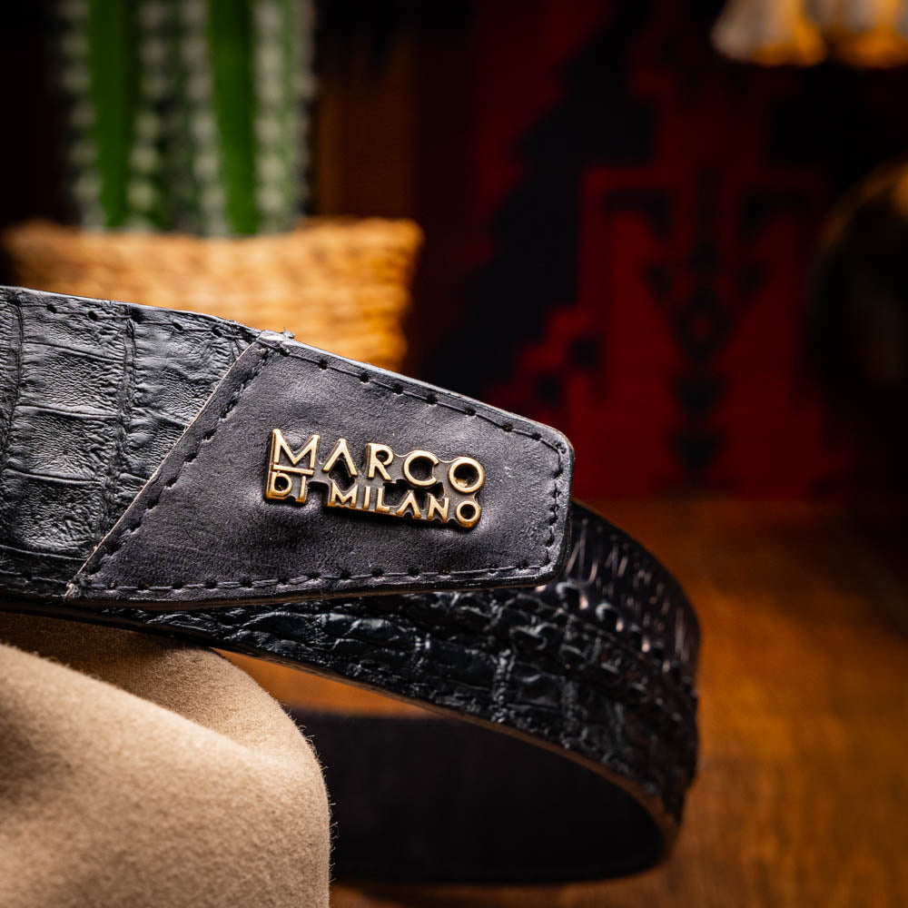 The Marco Di Milano Montana Belt Black features handcrafted black textured leather and a large gold MD monogram buckle, elegantly coiled against a white background.