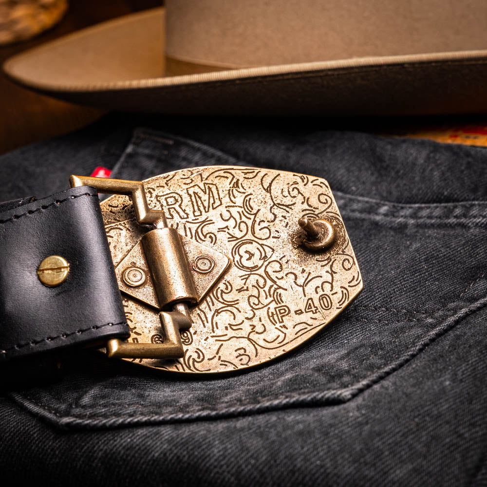 The Marco Di Milano Montana Belt Black features handcrafted black textured leather and a large gold MD monogram buckle, elegantly coiled against a white background.