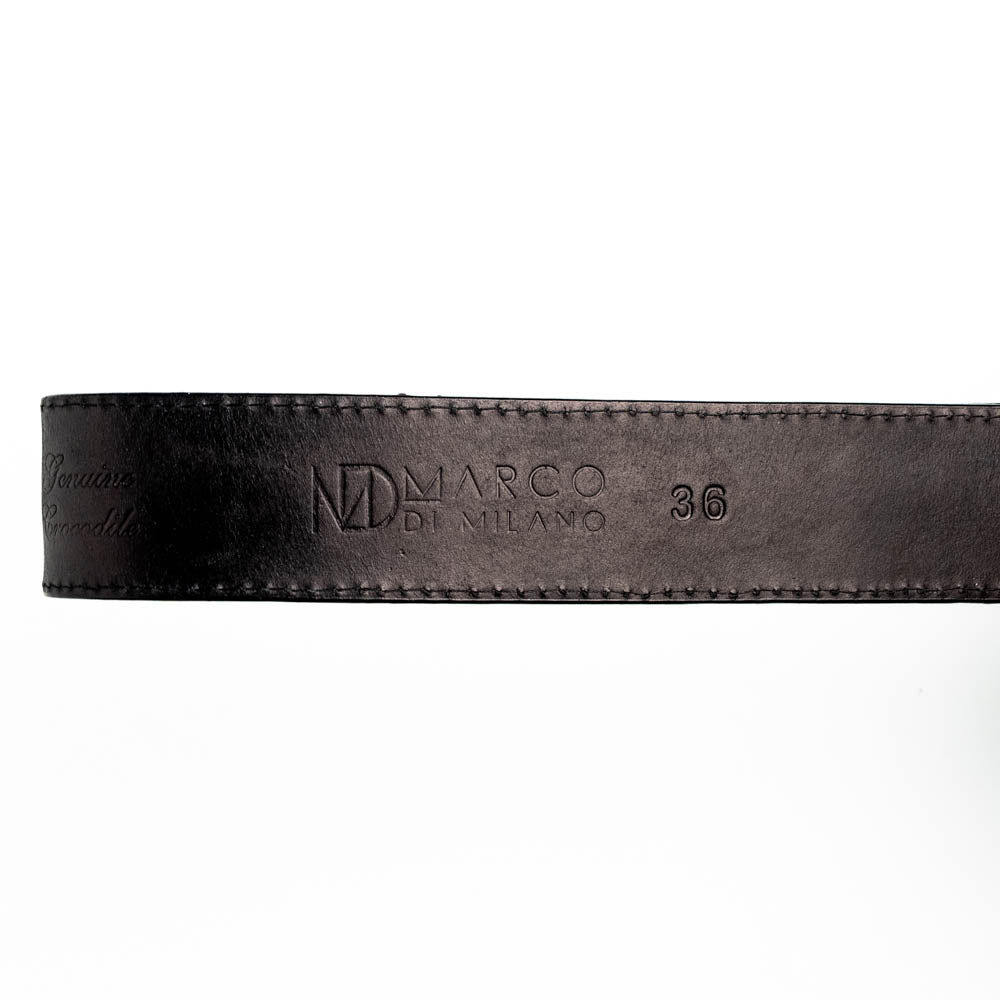 The Marco Di Milano Montana Belt Black features handcrafted black textured leather and a large gold MD monogram buckle, elegantly coiled against a white background.