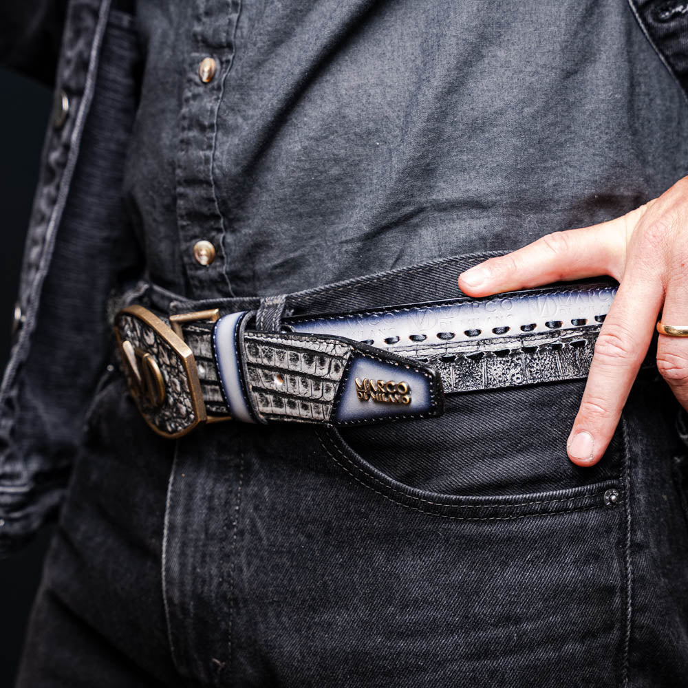The Montana Belt Stone Gray by Marco Di Milano is a handcrafted leather belt, featuring a gold MD logo buckle and embossed branding on the caiman crocodile strap.