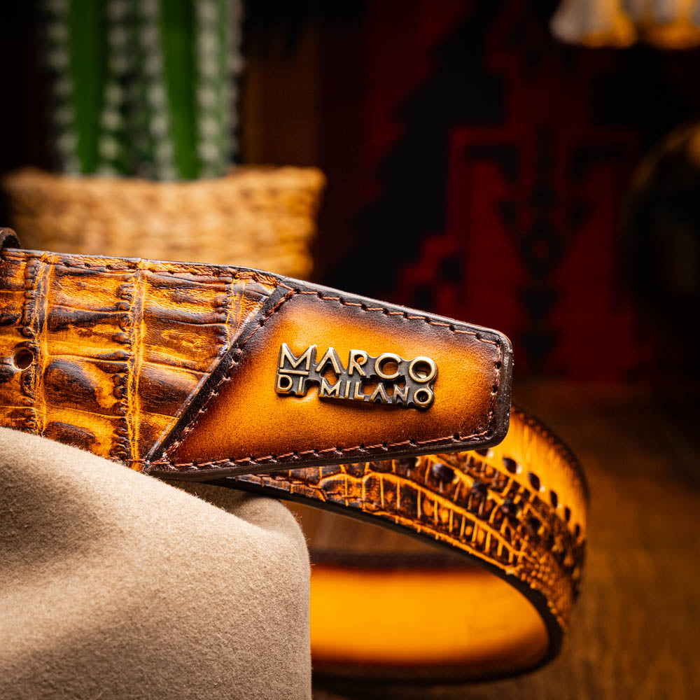 The Montana Belt Mustard Brown by Marco Di Milano features a brown caiman crocodile texture, a bold gold "MD" buckle, and "MARCO DI MILANO" embossed on the side, reflecting the brand’s renowned craftsmanship.