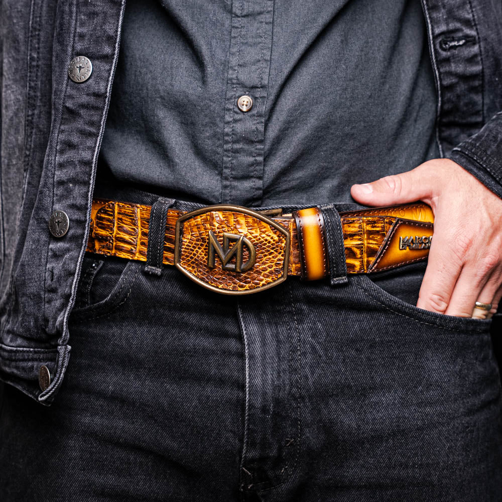 The Montana Belt Mustard Brown by Marco Di Milano features a brown caiman crocodile texture, a bold gold "MD" buckle, and "MARCO DI MILANO" embossed on the side, reflecting the brand’s renowned craftsmanship.