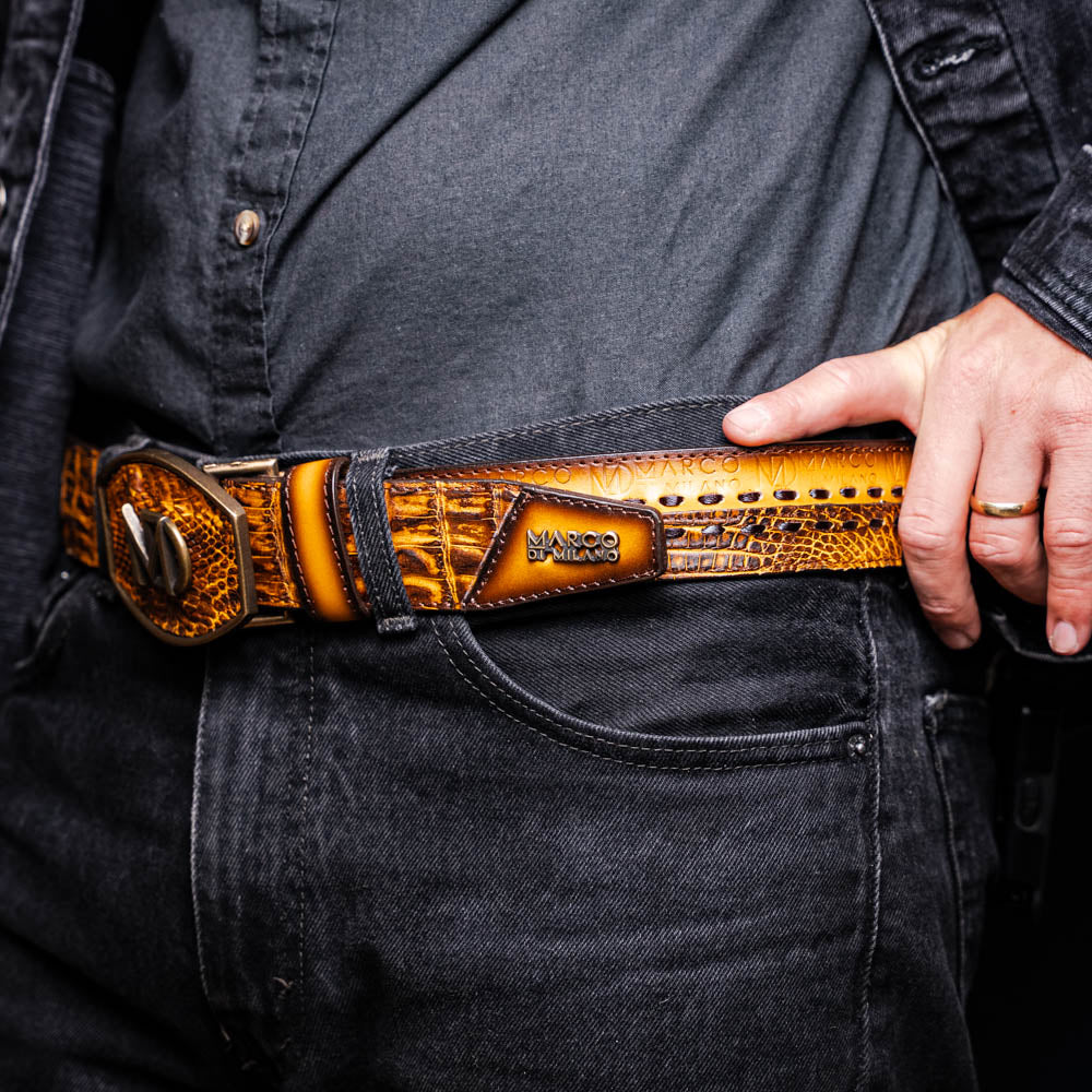 The Montana Belt Mustard Brown by Marco Di Milano features a brown caiman crocodile texture, a bold gold "MD" buckle, and "MARCO DI MILANO" embossed on the side, reflecting the brand’s renowned craftsmanship.