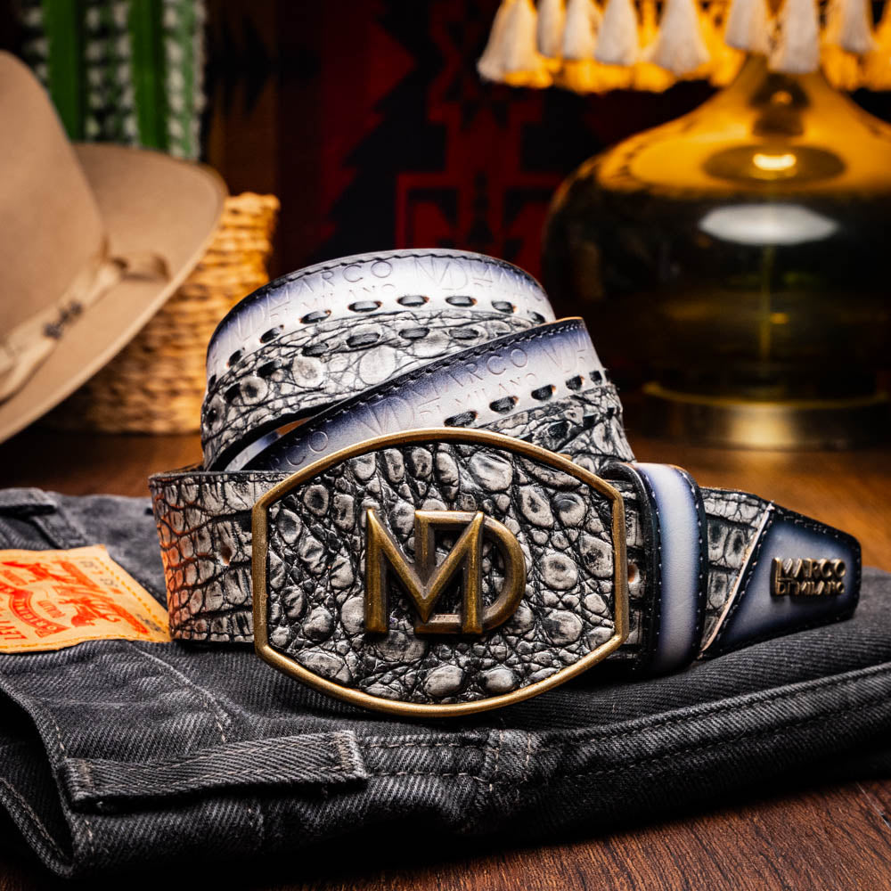 The Montana Belt Stone Gray by Marco Di Milano is a handcrafted leather belt, featuring a gold MD logo buckle and embossed branding on the caiman crocodile strap.