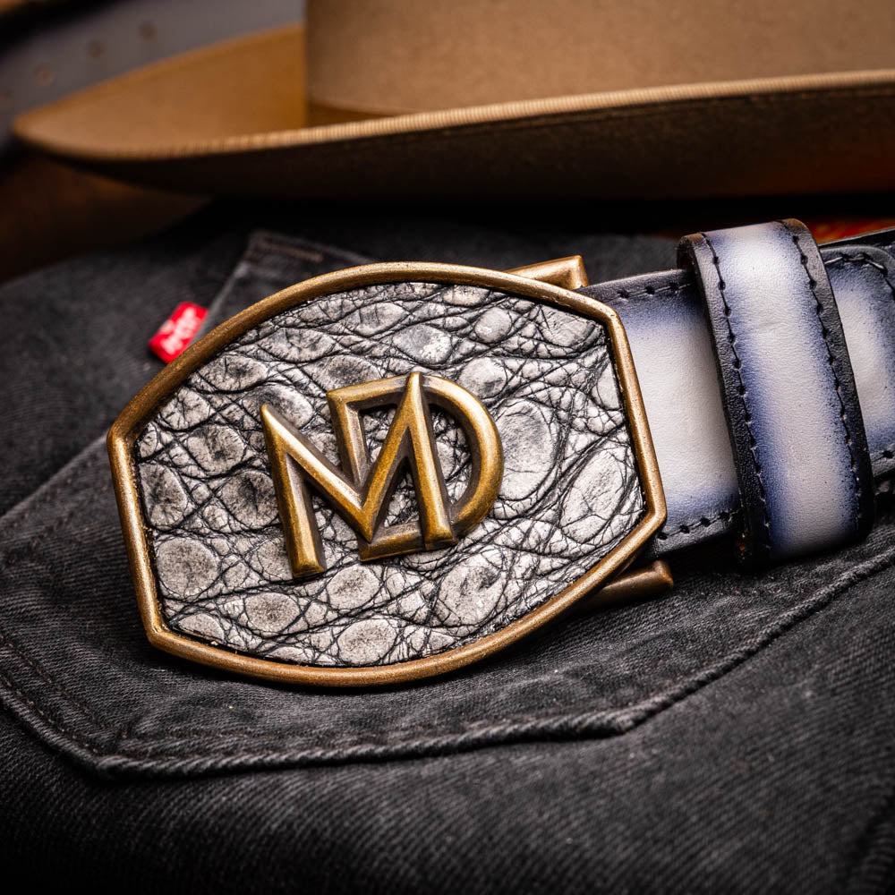 The Montana Belt Stone Gray by Marco Di Milano is a handcrafted leather belt, featuring a gold MD logo buckle and embossed branding on the caiman crocodile strap.