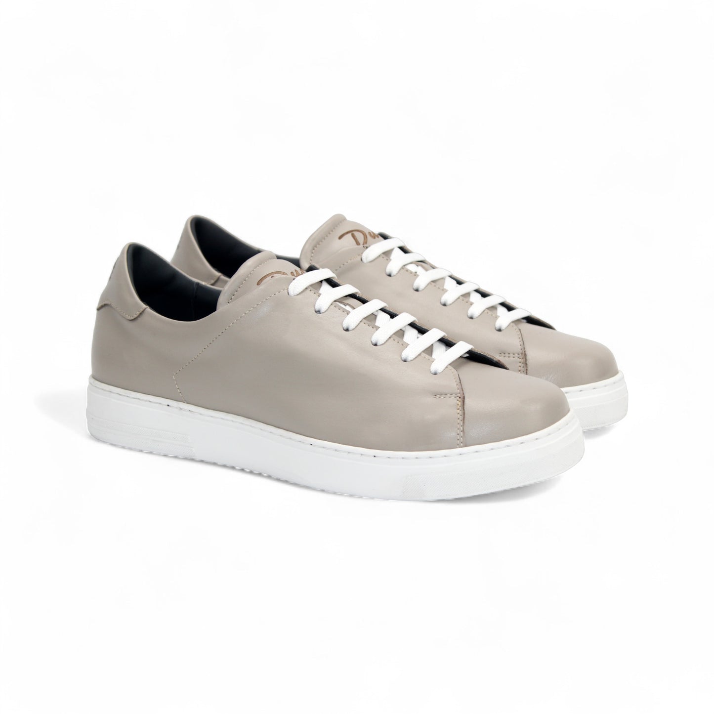 The Duca Di Matiste Duca Monza Grey is a genuine leather low-top sneaker in beige, with white laces and a white sole. Shown from the side on a plain white background, these shoes are perfect for everyday wear.