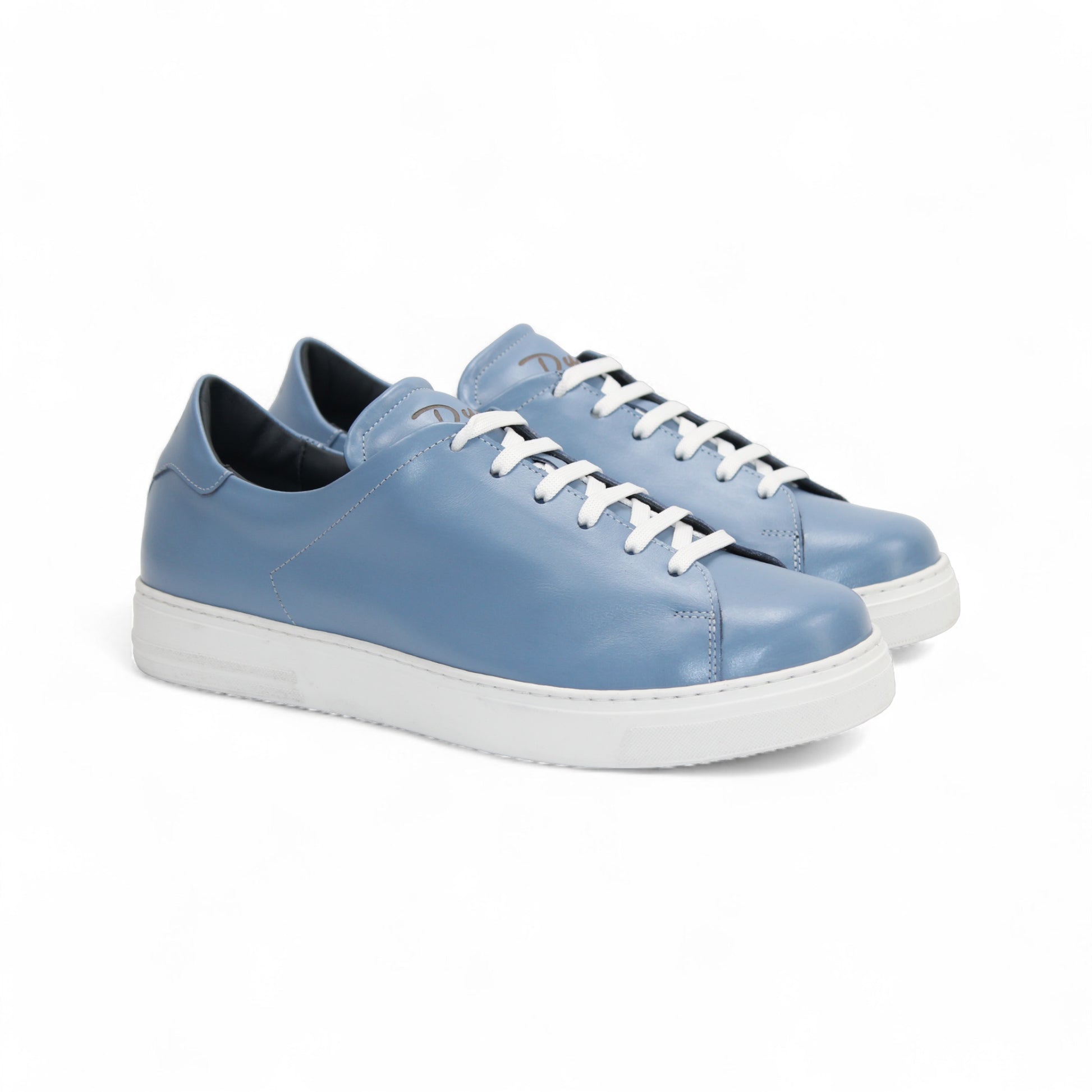 The Duca Monza Light Blue sneaker by Duca Di Matiste features genuine leather in light blue, white laces, and a thick white sole—an effortlessly versatile shoe that highlights Italian craftsmanship, shown in profile on a plain white background.