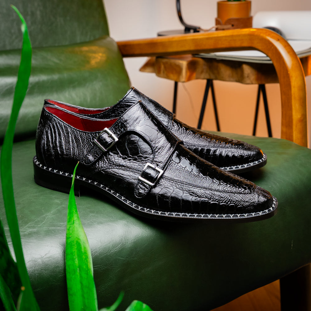 The Marco Di Milano Napoli Black is a pair of genuine ostrich leg dress shoes featuring a textured pattern, double monk strap, and brown branded sole—one shoe upright, the other showing the sole.
