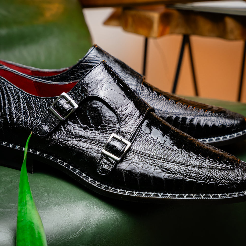 The Marco Di Milano Napoli Black is a pair of genuine ostrich leg dress shoes featuring a textured pattern, double monk strap, and brown branded sole—one shoe upright, the other showing the sole.