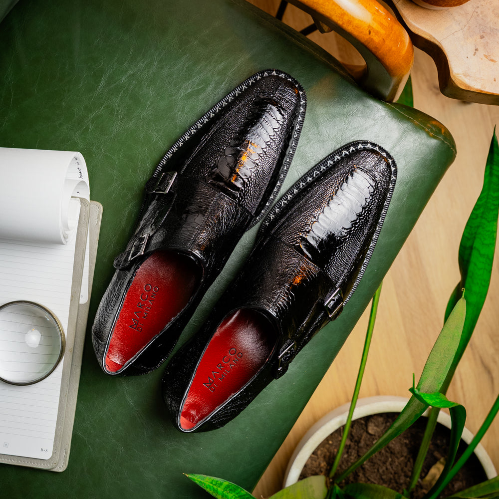 The Marco Di Milano Napoli Black is a pair of genuine ostrich leg dress shoes featuring a textured pattern, double monk strap, and brown branded sole—one shoe upright, the other showing the sole.