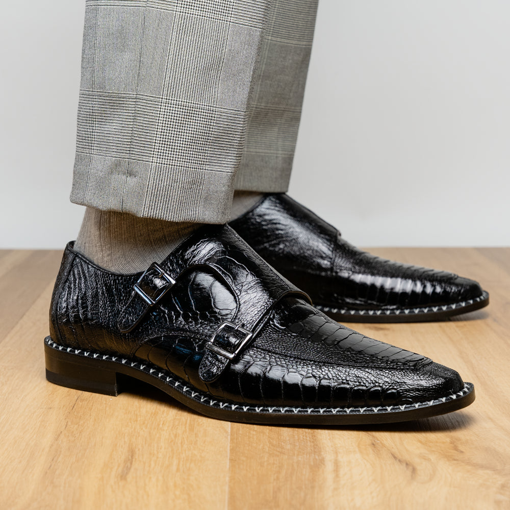 The Marco Di Milano Napoli Black is a pair of genuine ostrich leg dress shoes featuring a textured pattern, double monk strap, and brown branded sole—one shoe upright, the other showing the sole.