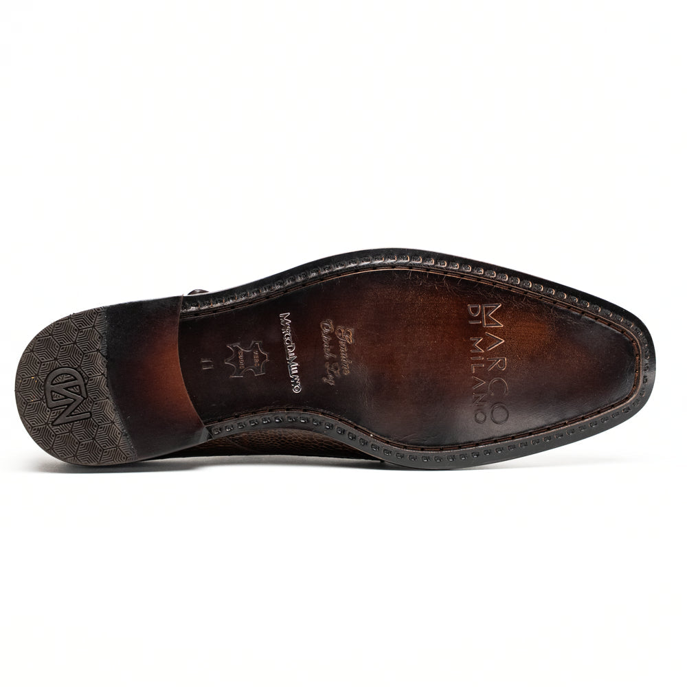 The Marco Di Milano Napoli Brown features brown leather double monk strap dress shoes with a genuine ostrich leg pattern and gold buckles, shown with one shoe upright and the other on its side.